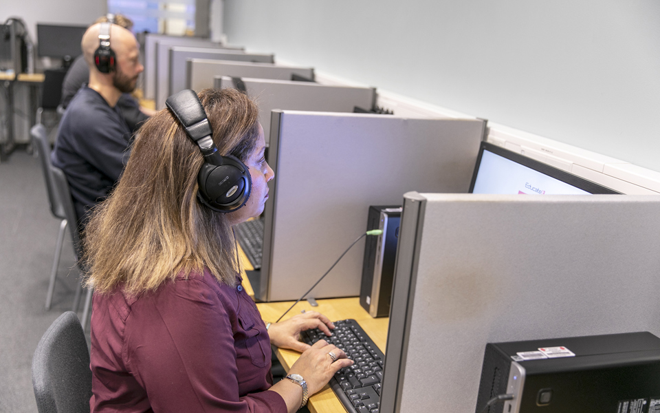 Vuxenutbildningselever som sitter framför datorer
